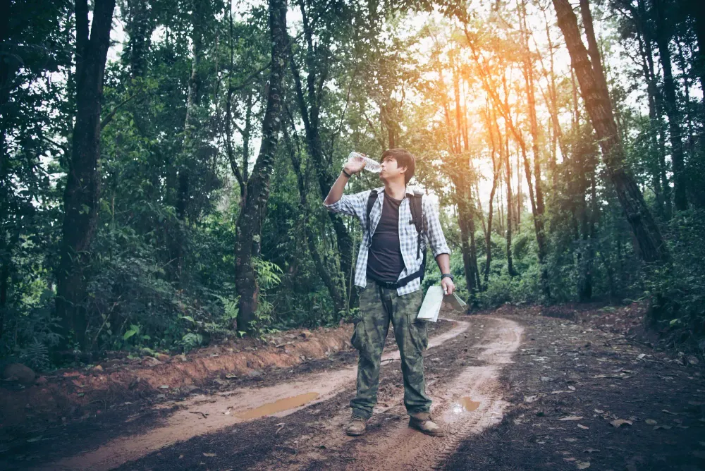 hiker drinking water in the woods